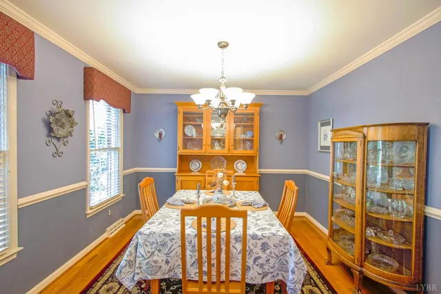a view of a dining room with furniture a chandelier and wooden floor
