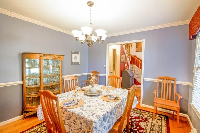 a view of a dining room with furniture a chandelier and wooden floor