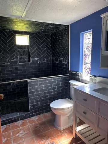 a bathroom with a toilet a sink and mirror