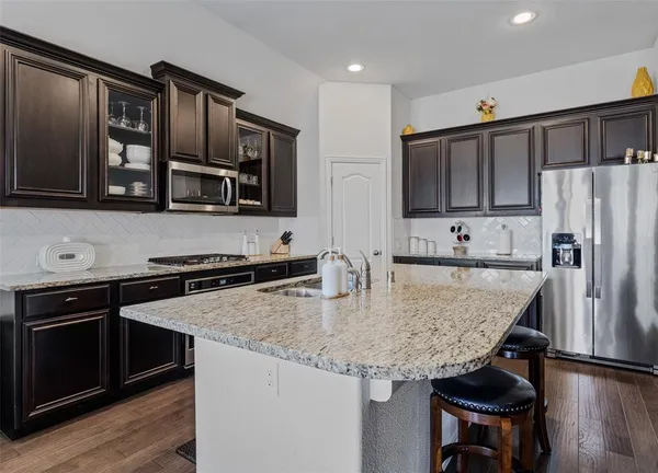a kitchen with stainless steel appliances granite countertop a stove a refrigerator and a microwave