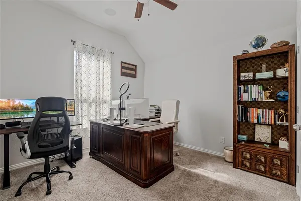 a view of a workspace with furniture and a window