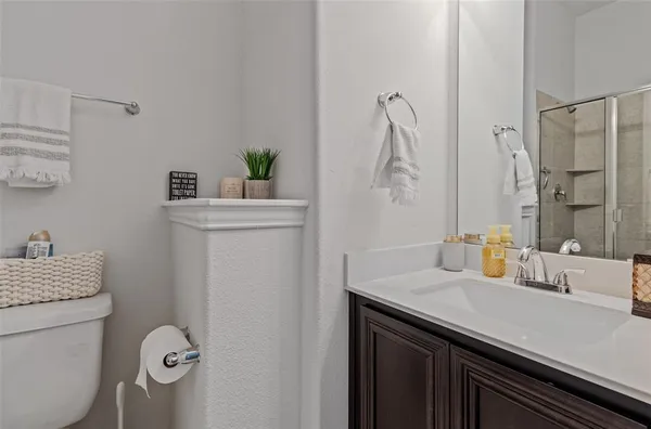 a bathroom with a granite countertop sink a toilet and shower