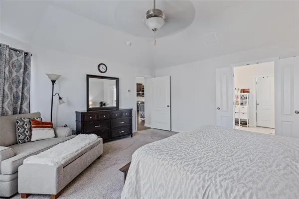 a spacious bedroom with a bed and a dresser