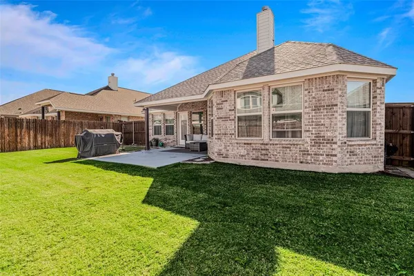 a view of a house with a big yard potted plants and large tree