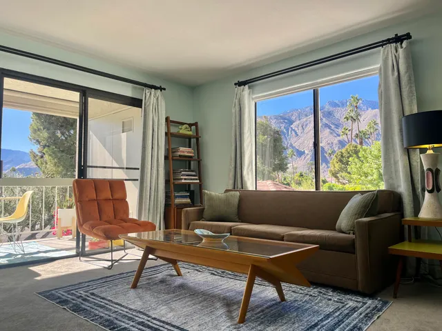 a living room with furniture a rug and a large window