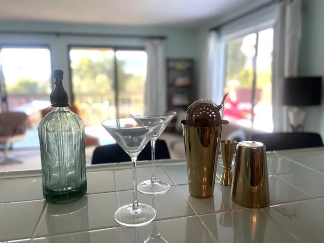 a living room with furniture a rug dining table and a large window