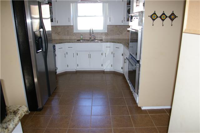Kitchen with tile floors, granite counters and tile backsplash