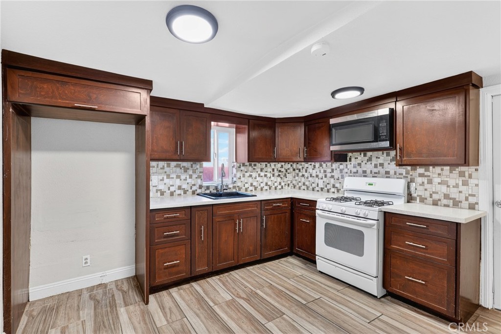 806 West Spruce Street Compton, CA 90220 - Photo 11 of 41 a kitchen with stainless steel appliances granite countertop a sink and stove top oven
