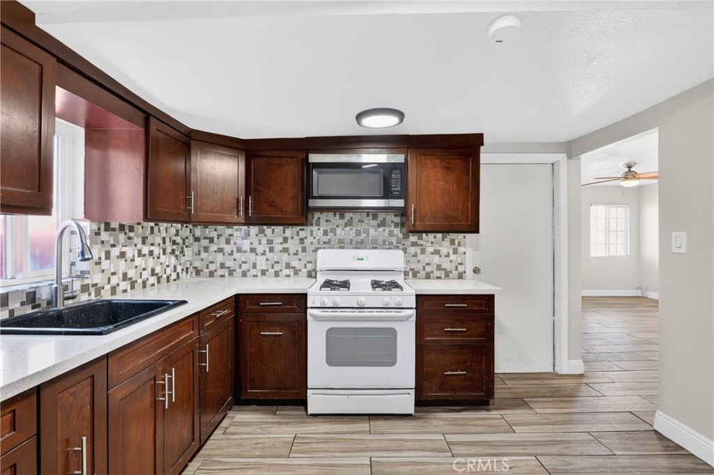806 West Spruce Street Compton, CA 90220 - Photo 12 of 41 a kitchen with stainless steel appliances granite countertop a stove and a sink