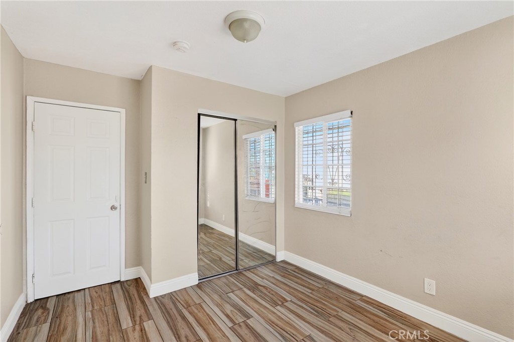 806 West Spruce Street Compton, CA 90220 - Photo 15 of 41 an empty room with wooden floor and windows