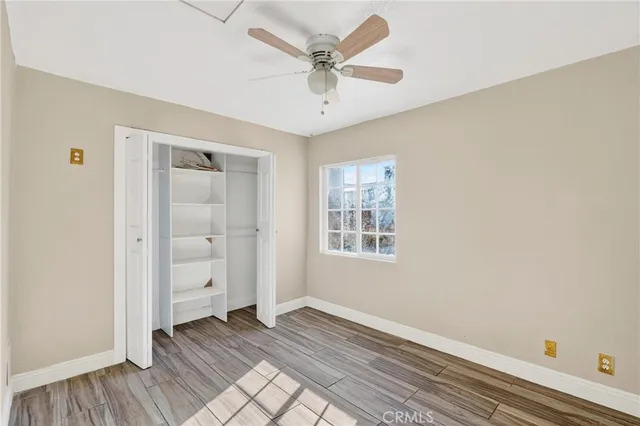 an empty room with windows and fan