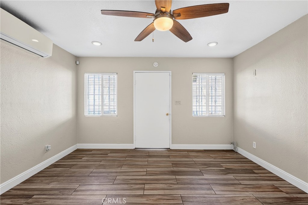 806 West Spruce Street Compton, CA 90220 - Photo 8 of 41 an empty room with wooden floor ceiling fan and windows