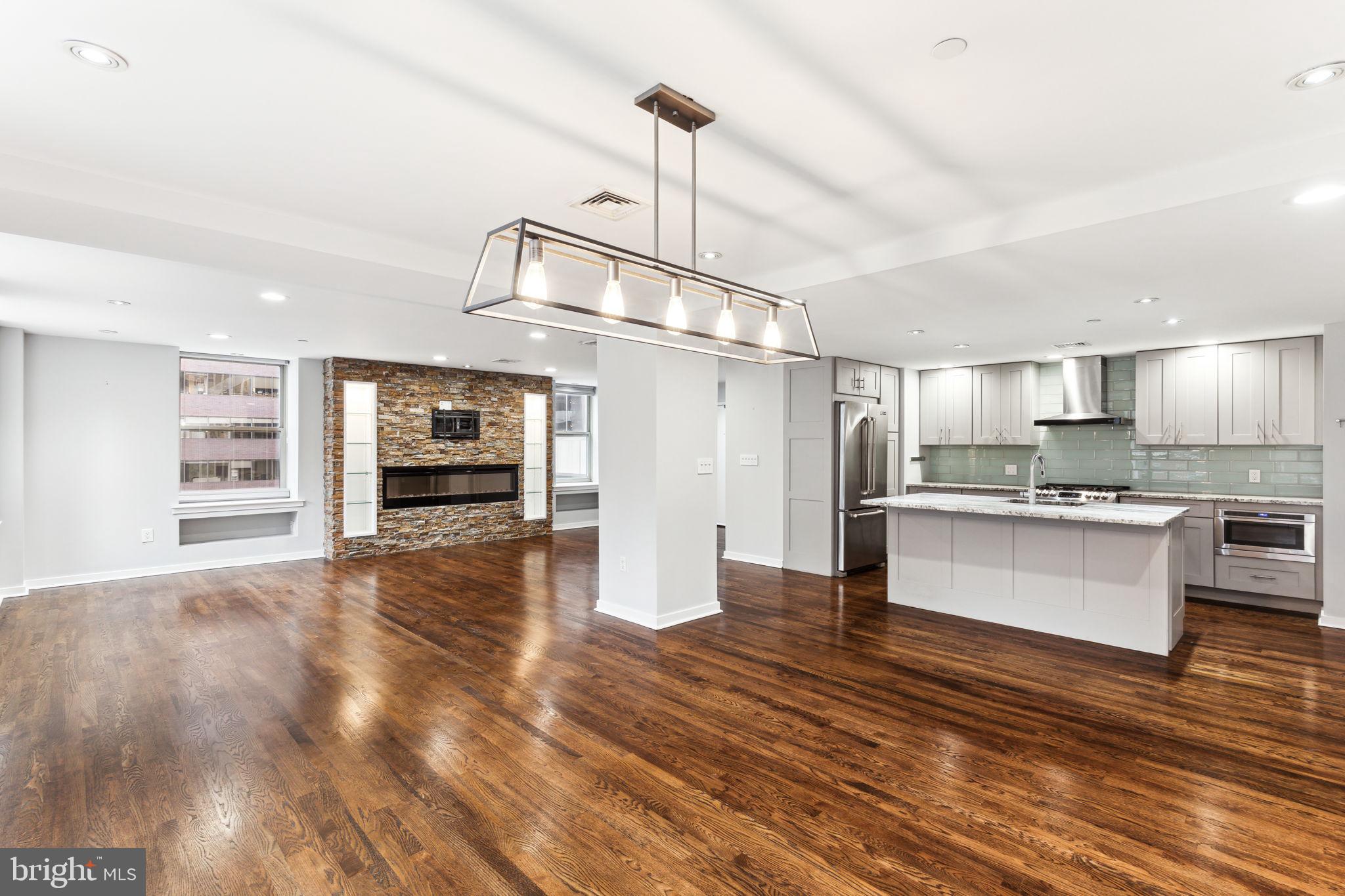 a kitchen with stainless steel appliances kitchen island wooden floors cabinets and dining table