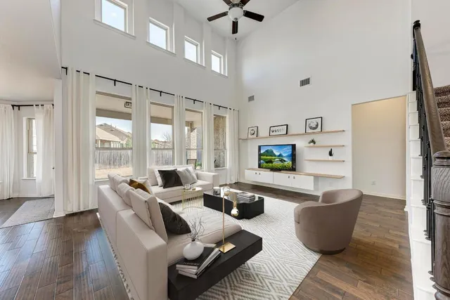 a living room with furniture wooden floor and large window