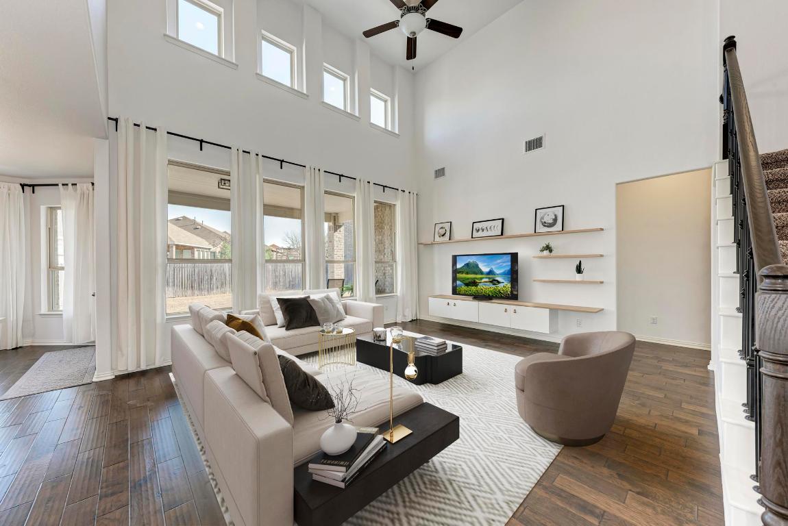 a living room with furniture wooden floor and large window