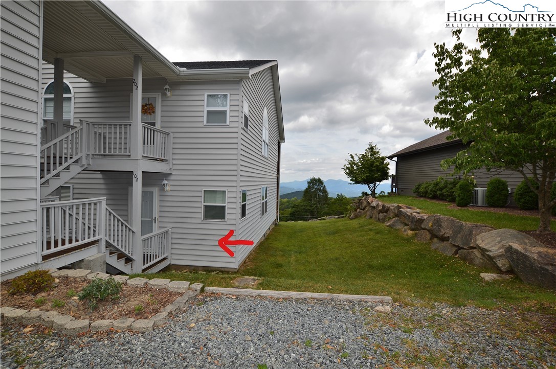 101 North Pinnacle Ridge Road, Unit A102 Beech Mountain, NC 28604 - Photo 27 of 28 a backyard of a house with wooden fence and a tree