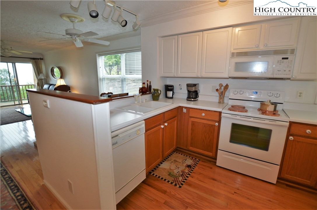 101 North Pinnacle Ridge Road, Unit A102 Beech Mountain, NC 28604 - Photo 3 of 28 a kitchen with a sink a stove and cabinets
