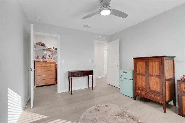 a bedroom with a bed and a flat tv screen on dresser