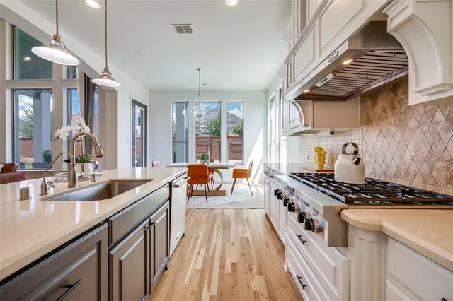 a kitchen with sink stove and cabinets