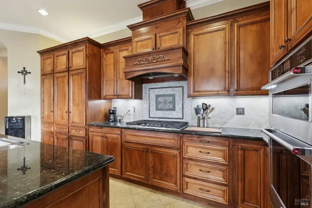 a kitchen with stainless steel appliances granite countertop a sink stove and cabinets