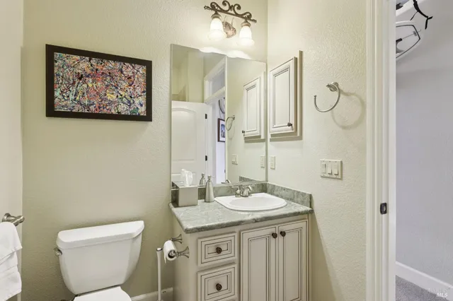 a bathroom with a granite countertop shower sink mirror and toilet