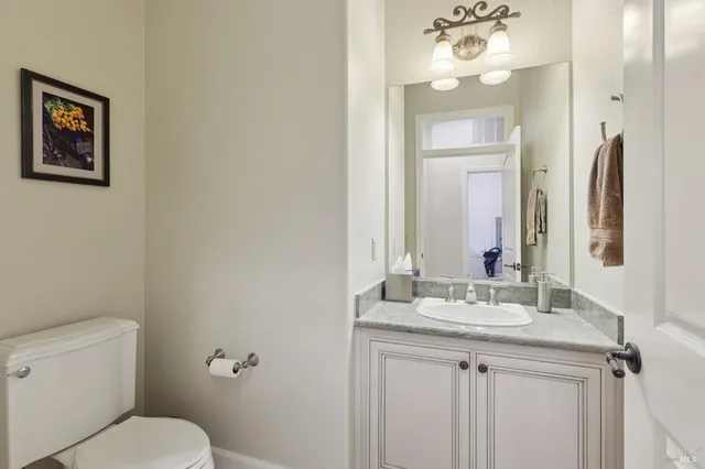 a bathroom with a granite countertop toilet sink and a mirror