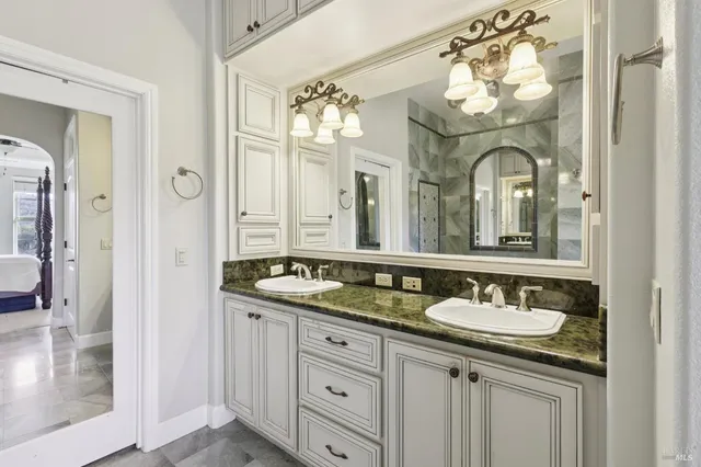 a bathroom with a granite countertop sink a mirror and a shower