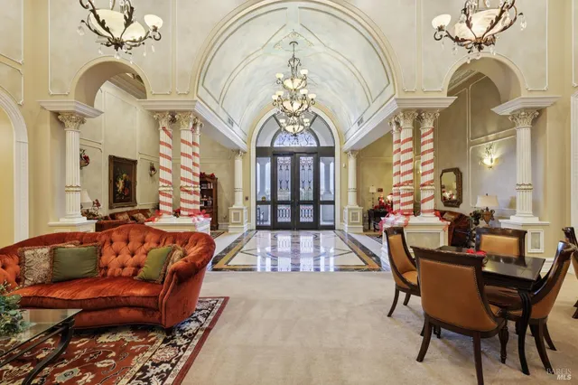a living room with furniture a chandelier and a rug