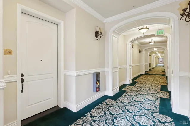 a view of a hallway with wooden floor and a bathroom