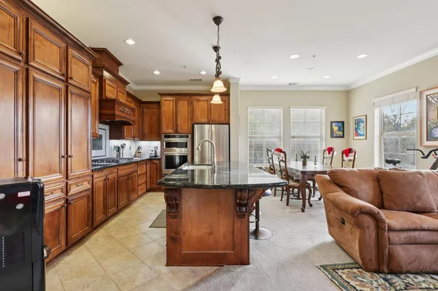 a living room with stainless steel appliances kitchen island granite countertop furniture a dining table and chairs