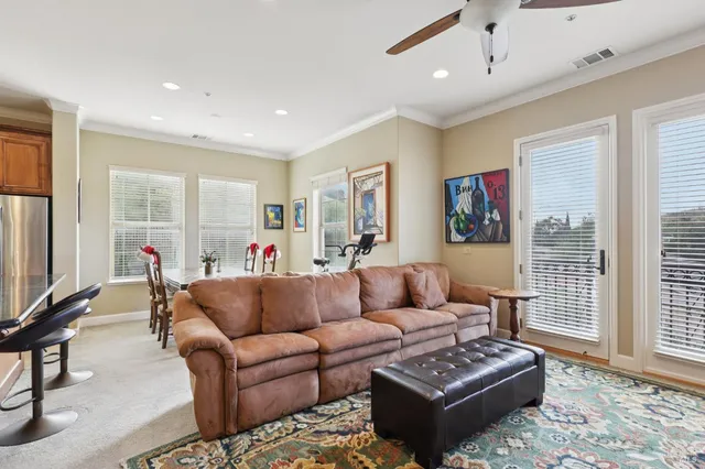 a living room with furniture a flat screen tv and a window