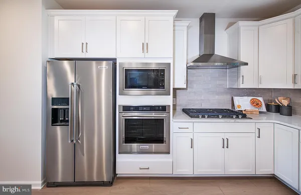 a kitchen with stainless steel appliances granite countertop a stove a refrigerator and a cabinets