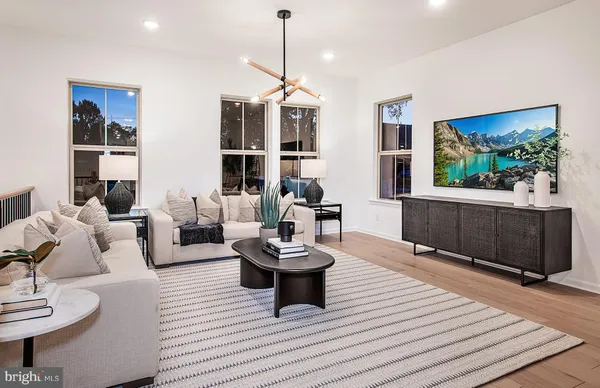 a living room with furniture a flat screen tv and a rug