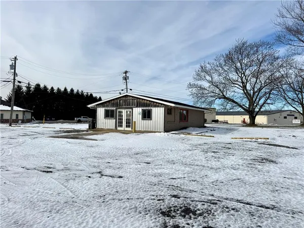 a front view of a house with a yard covered in snow