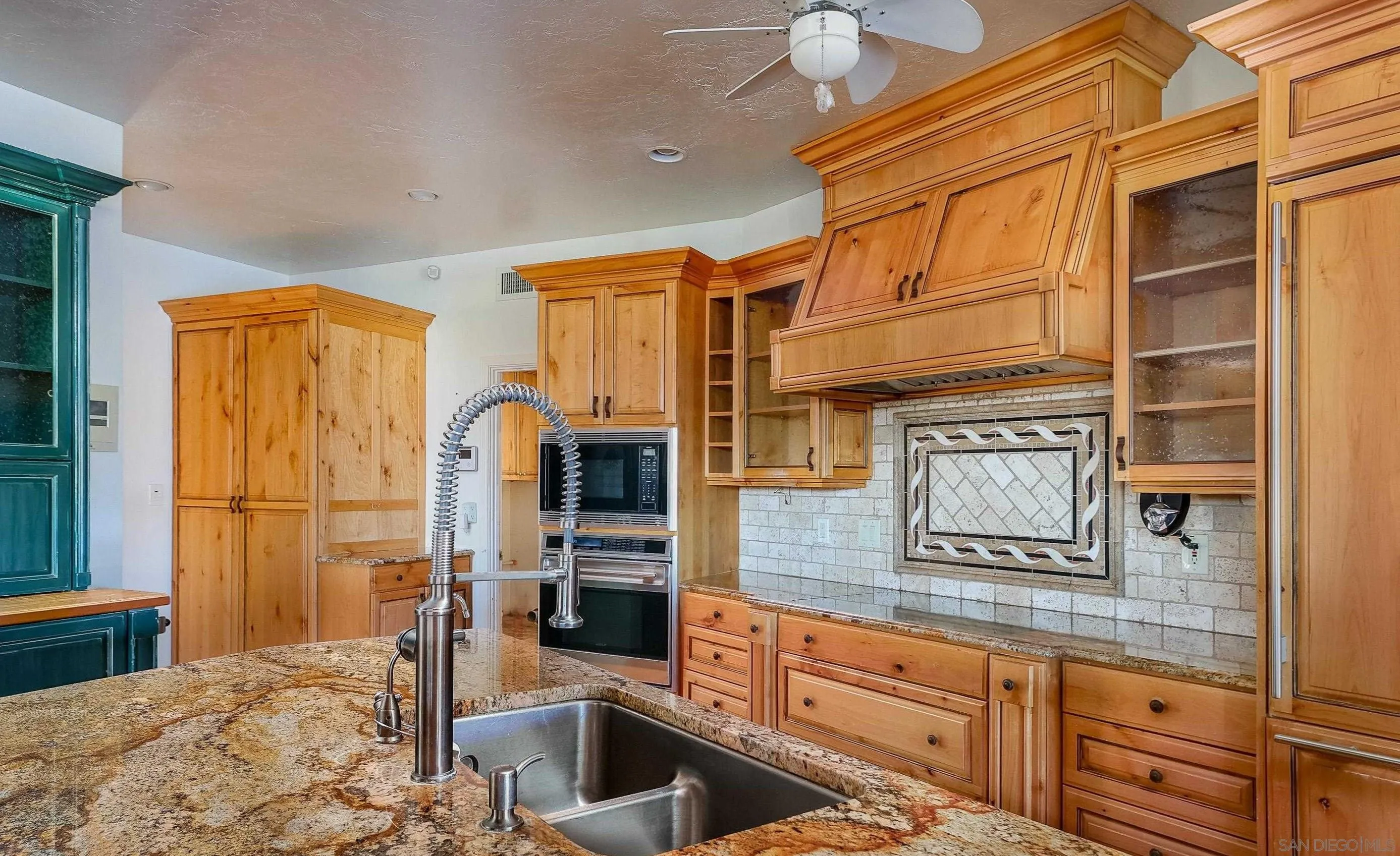 27303 Cool Water Ranch Road Valley Center, CA 92082 - Photo 17 of 30 a kitchen with stainless steel appliances granite countertop a sink and a refrigerator