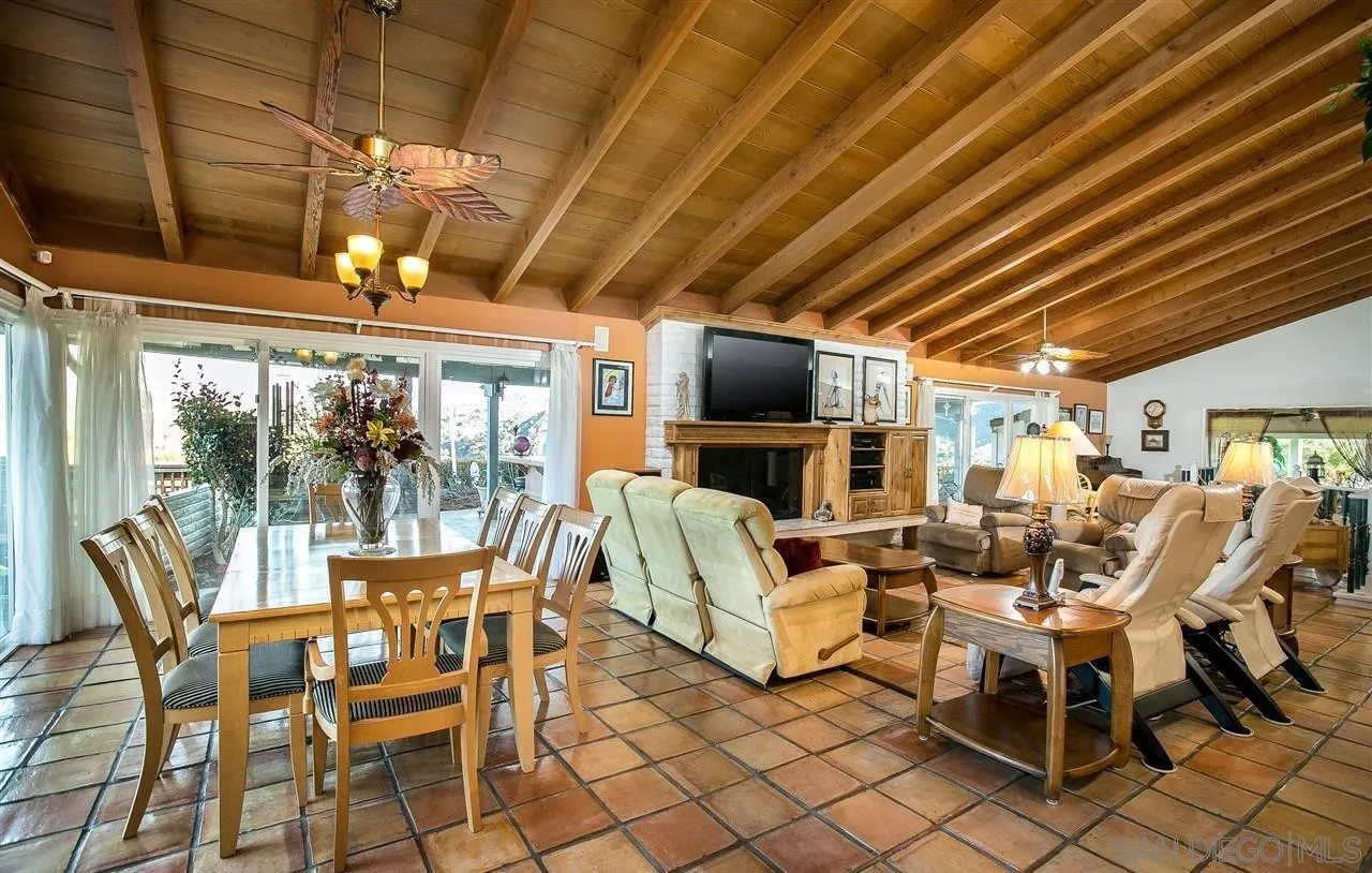 27303 Cool Water Ranch Road Valley Center, CA 92082 - Photo 5 of 30 a view of a dining room with furniture large windows and a chandelier