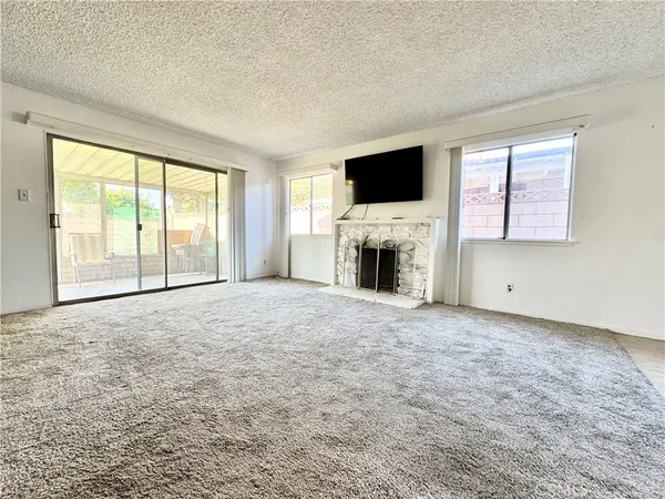 a view of empty room with a flat screen tv and a fireplace