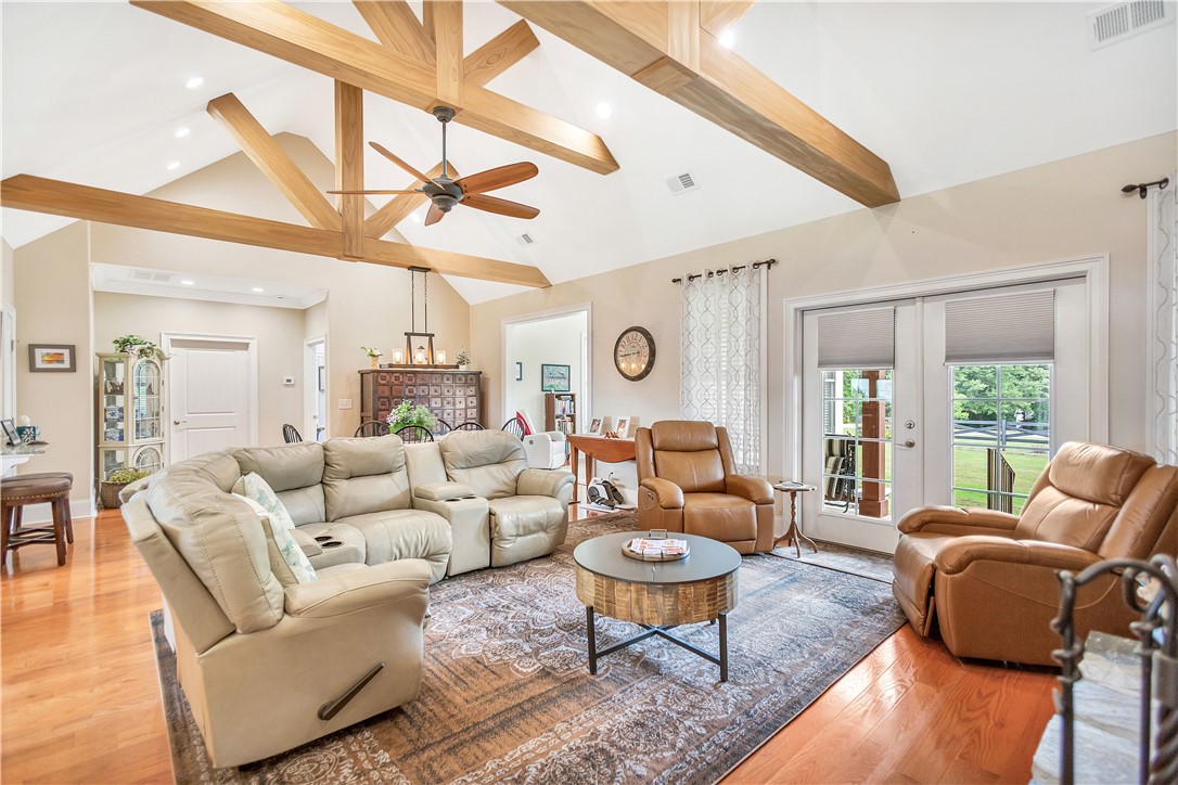 1204 Cherokee Road Townville, SC 29689 - Photo 12 of 44 Exposed wood beams accentuate the soaring vaulted ceiling, creating an inviting, open-concept living space with hardwood flooring.