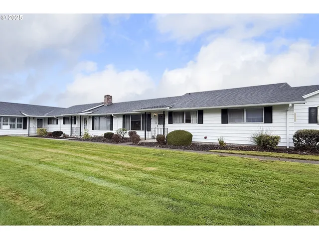 a living room with lots of furniture and view of kitchen