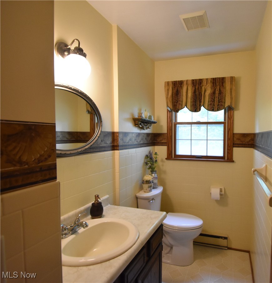 11676 Lisbon Road Salem, OH 44460 - Photo 10 of 38 Bathroom with a baseboard radiator, tile walls, vanity, a wainscoted wall, and tile patterned floors