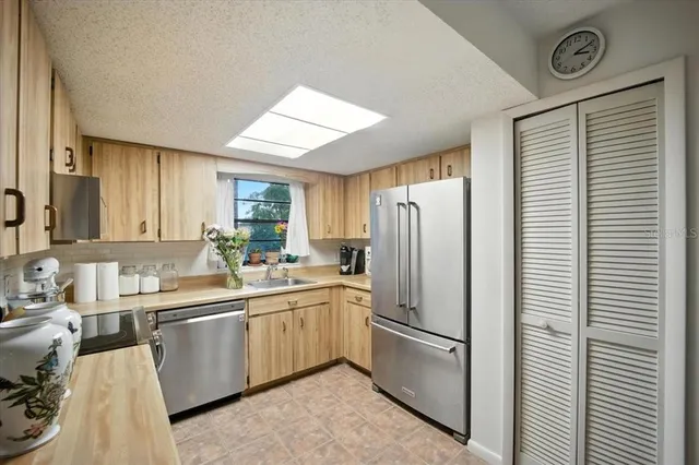 a kitchen with a sink a refrigerator and cabinets