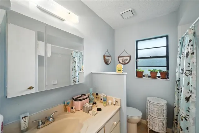 a bathroom with a sink a toilet and a window