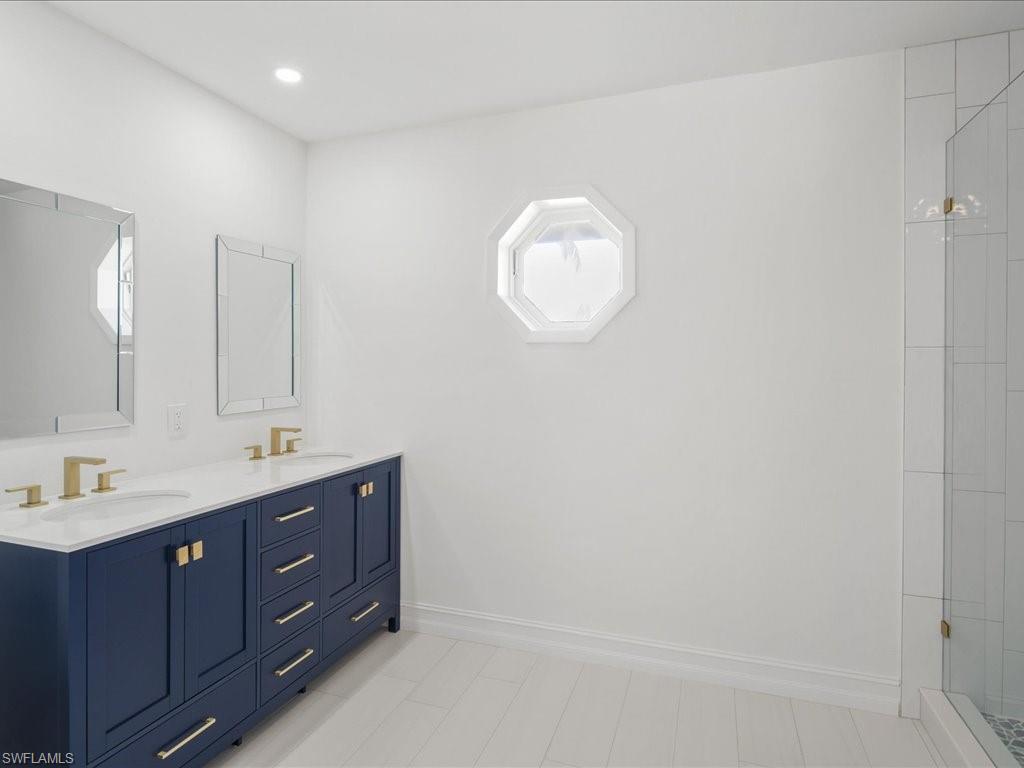262 Torrey Pines Point Naples, FL 34113 - Photo 14 of 24 a bathroom with a double vanity sink and mirror with window