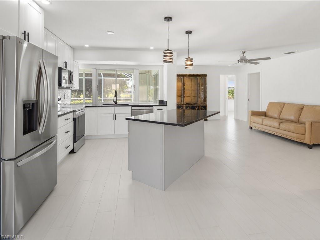 262 Torrey Pines Point Naples, FL 34113 - Photo 5 of 24 a kitchen with stainless steel appliances granite countertop a refrigerator a oven and white cabinets