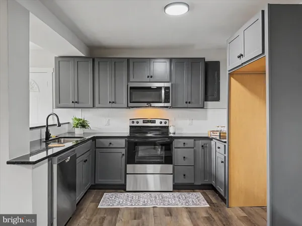 a kitchen with a sink stove and microwave