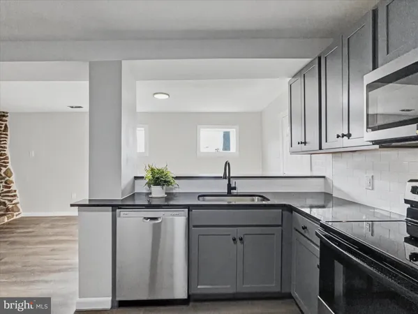 a kitchen with stainless steel appliances granite countertop a sink stove and cabinets
