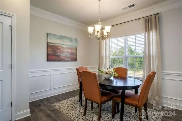 a dining room with furniture a chandelier and wooden floor