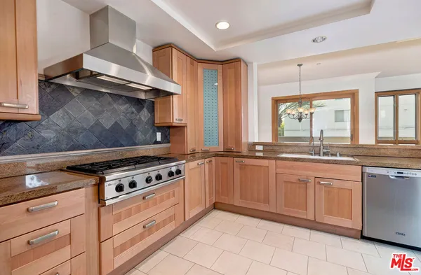 a kitchen with granite countertop a stove sink and cabinets