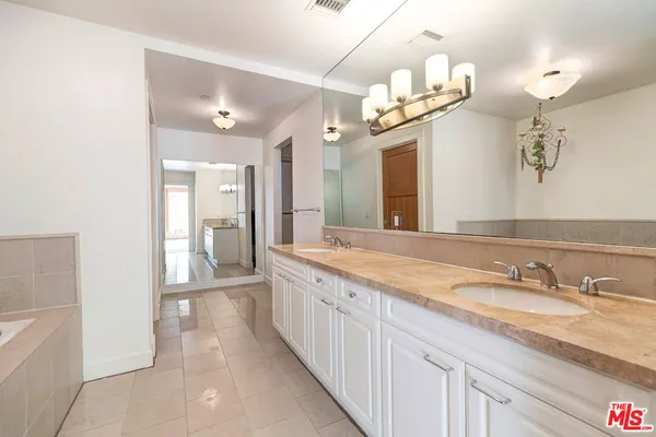 a spacious bathroom with a granite countertop sink a mirror and a shower
