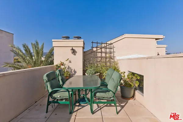 a balcony with table and chairs